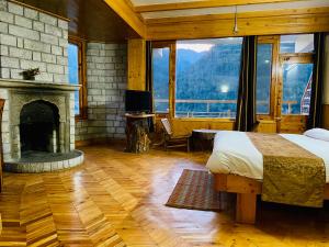 a bedroom with a fireplace and a bed and a television at Vashisht valley hotel in Manāli
