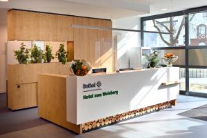 a reception desk in a building with plants on it at Bethel Hotel zum Weinberg in Bad Neuenahr-Ahrweiler