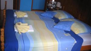 a large bed with blue and yellow sheets and pillows at Perun Guest House in Mlini