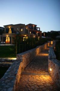 a stone retaining wall in front of a house at Villa Brio Exclusive in Skala Kefalonias