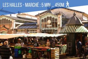 un mercado frente a un gran edificio con gente en él en Cosy Up - Vieux Port - Hyper Centre, en La Rochelle