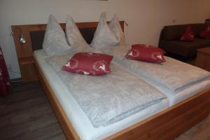 een bed met rode en witte kussens erop bij Appartement Farina in Kaprun