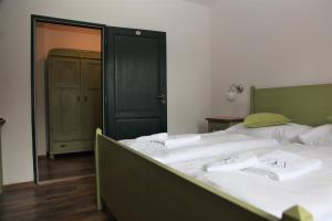 1 dormitorio con 1 cama grande con sábanas blancas en Aparthotel Mádr, en Modrava