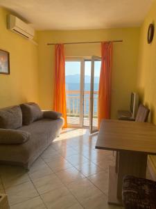 a living room with a couch and a view of the ocean at Villa nad Morem in Podaca