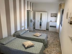 een kleine kamer met 2 bedden en een spiegel bij Casa Josy in Francavilla di Sicilia