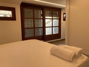 a bed with a towel on it in front of a window at Apartamento céntrico con WIFI y climatizado de 1 habitación y sofá-cama para 3 personas in Santa Coloma de Farners