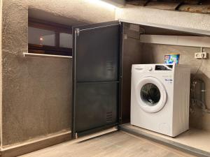 una lavadora y una lavadora en una habitación en Apartamento céntrico con WIFI y climatizado de 1 habitación y sofá-cama para 3 personas en Santa Coloma de Farners