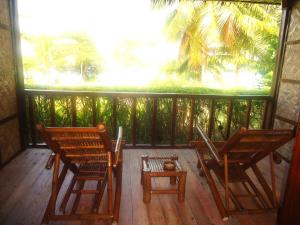 2 sillas y una mesa en un porche en DACOZY Beach Resort, en Moalboal