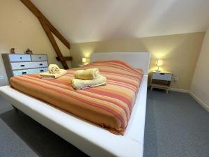 een slaapkamer met een groot bed en handdoeken bij TRAVERSIÈRE in Bedous