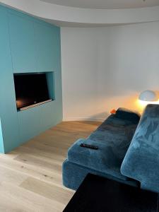 een woonkamer met een bank en een flatscreen-tv bij Umi in Oostende