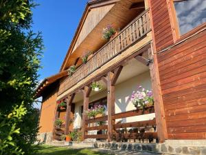 a house with flower boxes on the side of it at Pensiunea Rares in Bistriţa Bîrgăului