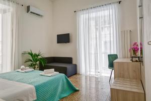 a hotel room with a bed, table and window at Sicilian Rooms Palermo in Palermo