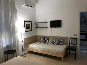 1 dormitorio con 1 cama y TV en la pared en B&B Cristina Garden, en Pisa