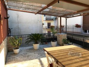 een patio met een tafel en potplanten op een balkon bij Casa Josy in Francavilla di Sicilia