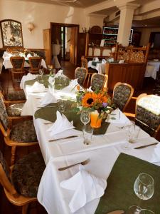 una mesa larga con manteles blancos y flores. en Hotel Stadt Olbernhau en Olbernhau