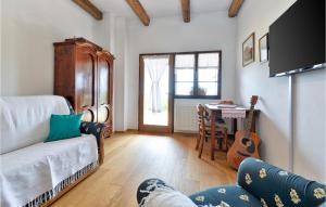 a living room with a couch and a table with a guitar at Cozy Home In Slavetic With Kitchen in Slavetić