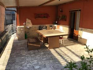 een patio met een houten tafel en stoelen bij Casa Josy in Francavilla di Sicilia