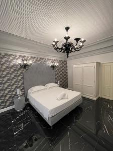 阿拉西奧的住宿－Casa Balzola - Suite Adamas，卧室配有白色的床和吊灯。