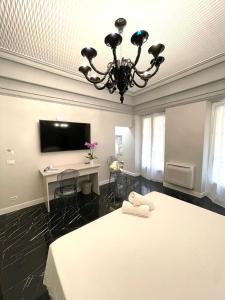 阿拉西奧的住宿－Casa Balzola - Suite Adamas，一间卧室配有一张床、一张书桌和一个吊灯。