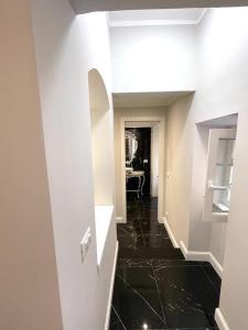 pasillo con suelo de baldosa negra y paredes blancas en Casa Balzola - Suite Adamas, en Alassio