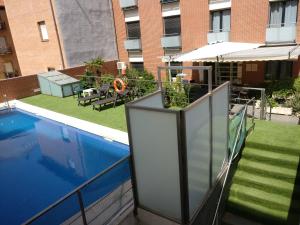 balcón con piscina y sombrilla en Hotel Apartamentos Don Juan I, en Alcalá de Henares