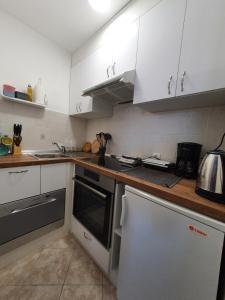 una cucina con armadi bianchi e piano cottura di Studio Apartman Fredi a Opatija