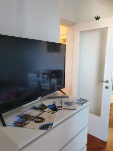 una grande TV a schermo piatto seduta sopra un comò di Studio Apartman Fredi a Opatija
