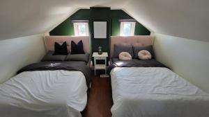 2 Betten in einem kleinen Zimmer mit grünen Wänden in der Unterkunft JstLikeHome - Old Ottawa in Ottawa