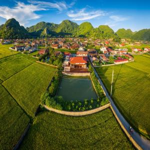 einem Luftblick auf ein Dorf mit See und Bergen in der Unterkunft Bac Son Homestay in Bắc Sơn