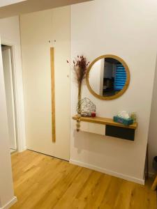 um quarto com um espelho na parede e uma prateleira em Bethlen Apartman em Odorheiu Secuiesc