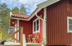 ein rotes Haus mit einer Veranda und einem Stuhl darauf in der Unterkunft Stunning Home In Vikbolandet With Wifi And 2 Bedrooms 