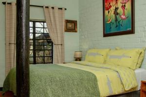 a bedroom with a bed with yellow sheets and a window at The Green Lantern - Howick in Howick