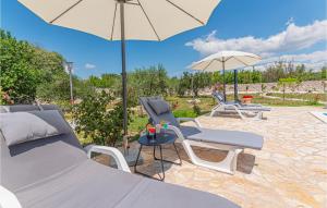 a patio with two chairs and an umbrella and a table at Pet Friendly Home In Vinovo Donje With Kitchen in Donje Vinovo
