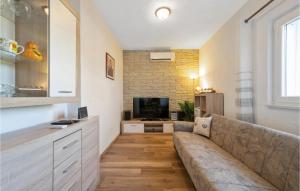 a living room with a couch and a television at Three-Bedroom Holiday Home In Vinovo Donje in Donje Vinovo
