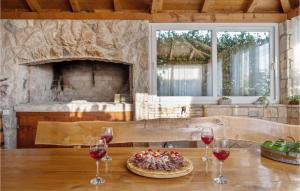 a table with two glasses of wine and a pizza at Three-Bedroom Holiday Home In Vinovo Donje in Donje Vinovo