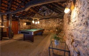 a room with a pool table in a stone wall at Three-Bedroom Holiday Home In Vinovo Donje in Donje Vinovo