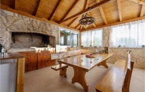 a kitchen with a wooden table and a stone fireplace at Pet Friendly Home In Vinovo Donje With Kitchen in Donje Vinovo