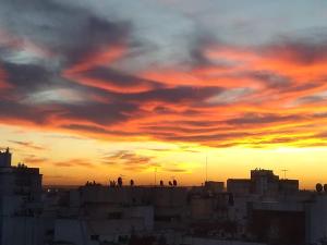 una puesta de sol sobre una ciudad con gente en los tejados en Hermosos atardeceres …, en Mar del Plata 11 fotos más