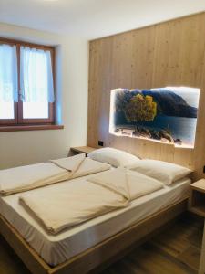 een slaapkamer met een bed met een foto aan de muur bij Casa dei Tabachi in Molveno