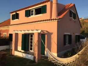 a house with a hammock in front of it at Foz - Sea View Cottage in Foz do Arelho