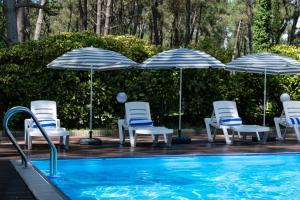 - un groupe de chaises longues et de parasols à côté de la piscine dans l'établissement Buxus Hotel Shekvetili, à Shekvetili