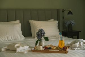 a tray of food and a drink on a bed at Buxus Hotel Shekvetili in Shekvetili