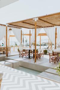 a pavilion with tables and chairs on the beach at Abonora Drymades in Dhërmi