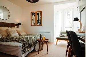 - une chambre avec un lit, un bureau et une chaise dans l'établissement Logis Hôtel de la Pointe du Cap Coz, à Fouesnant