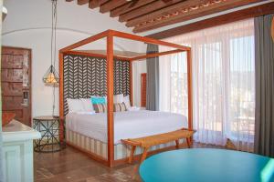 a bedroom with a canopy bed and a table at Casa Lisa in Acapulco
