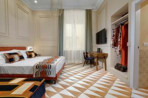 una camera con letto, scrivania e TV di YourHome - Maison Iovino Luxury Rooms a Sorrento