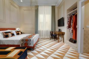 ソレントにあるYourHome - Maison Iovino Luxury Roomsのベッドと机とテレビのある寝室