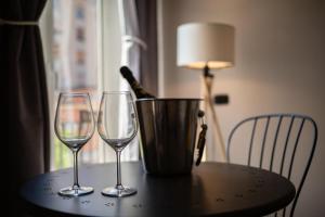 un tavolo con due bicchieri di vino e un secchio sopra di Sicilian Rooms Palermo a Palermo