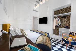 Schlafzimmer mit einem Bett und einem Schreibtisch mit einem Laptop in der Unterkunft YourHome - Maison Iovino Luxury Rooms in Sorrent