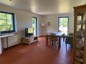 a living room with a table and a tv at Hofgut Wollin GmbH in Putgarten